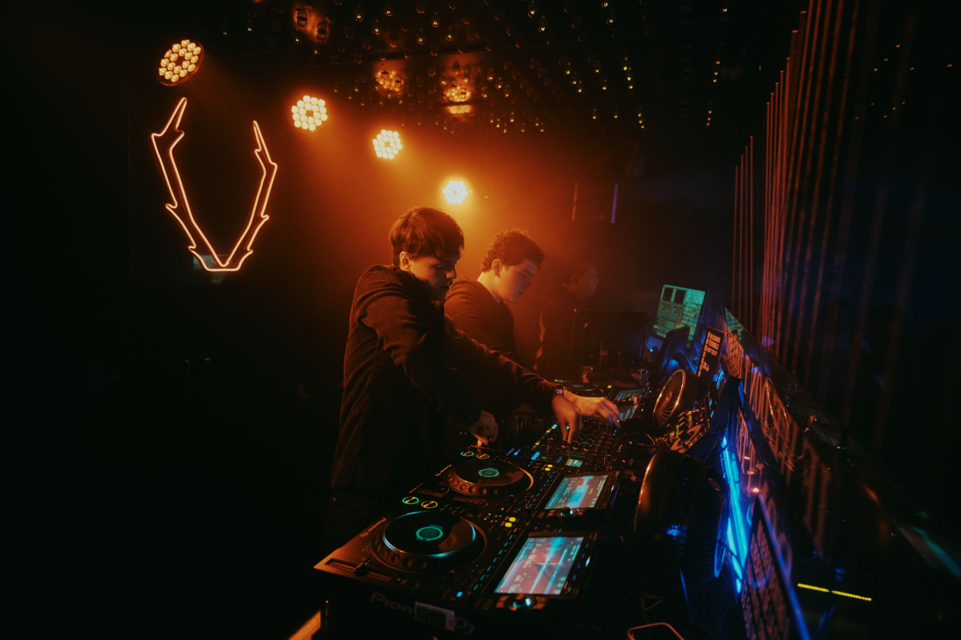DJs performing behind decks in a club