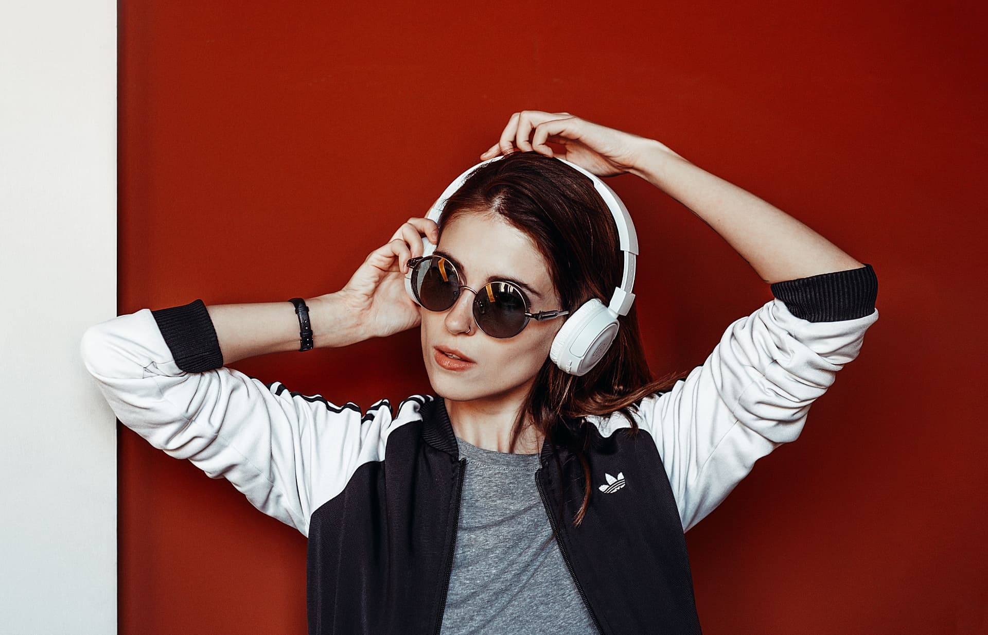 Artist with white headphones against a red wall