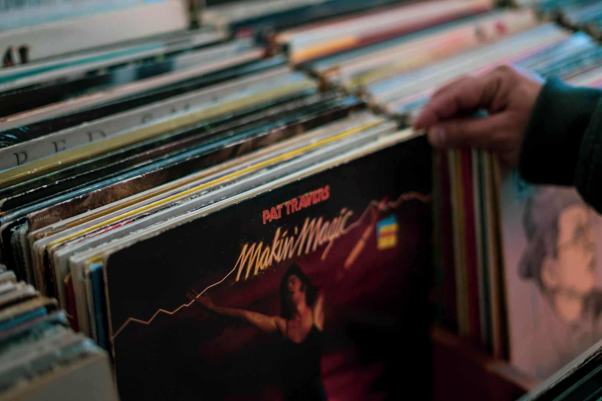 Hands browsing vinyl records in a crate