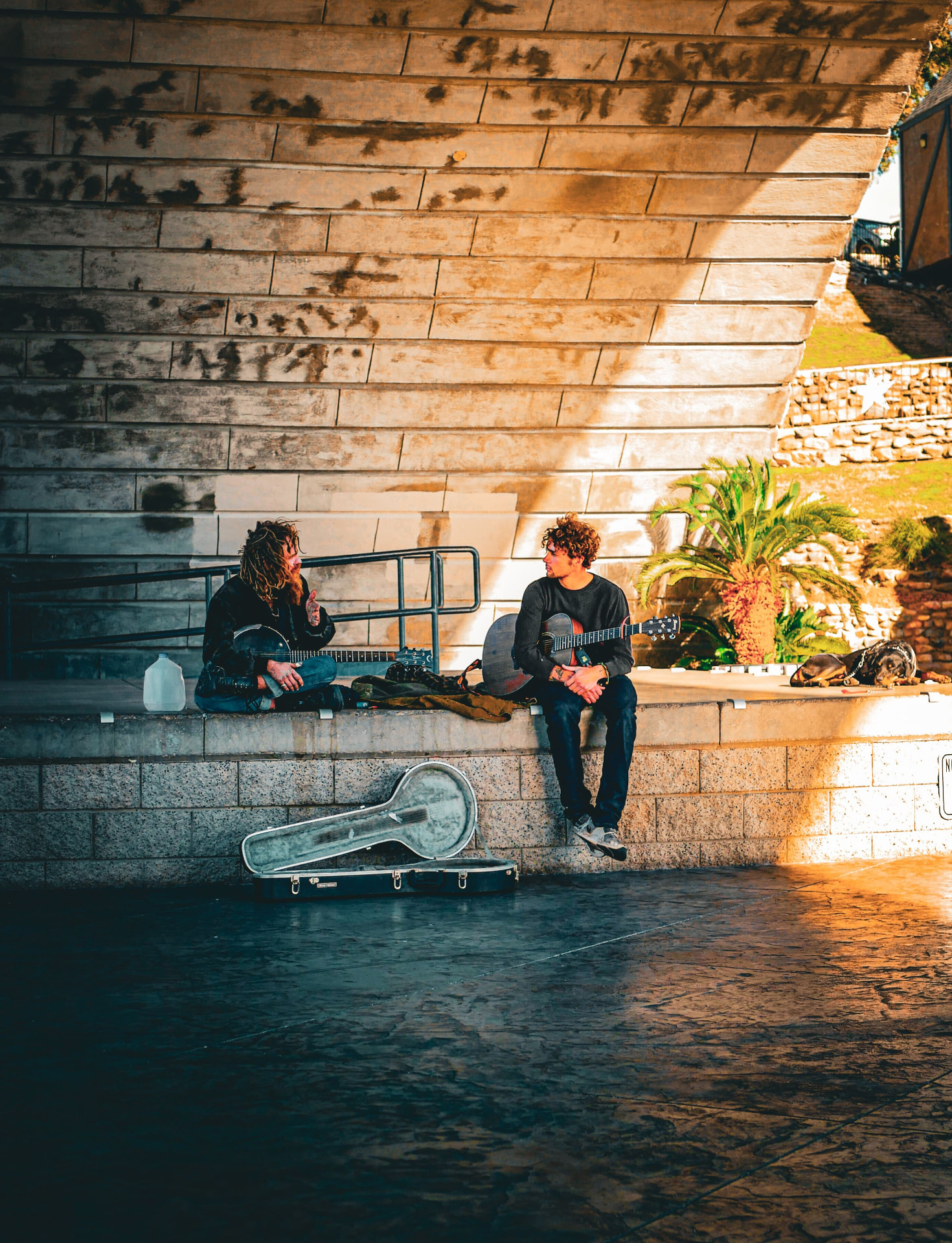 Two street musicians playing guitar in golden light